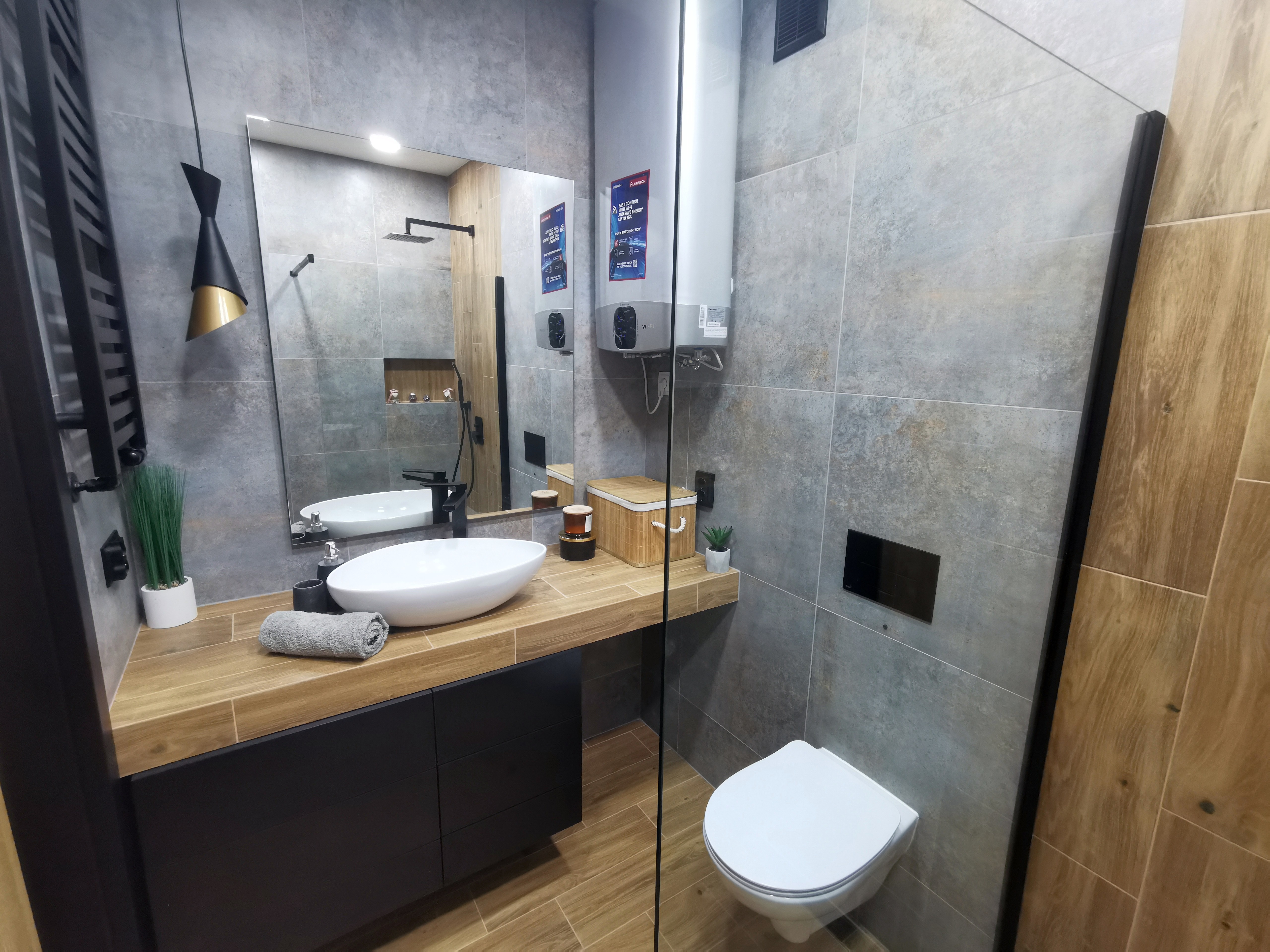 Nowoczesna łazienka wykończona pod klucz z szarymi płytkami i drewnianymi akcentami