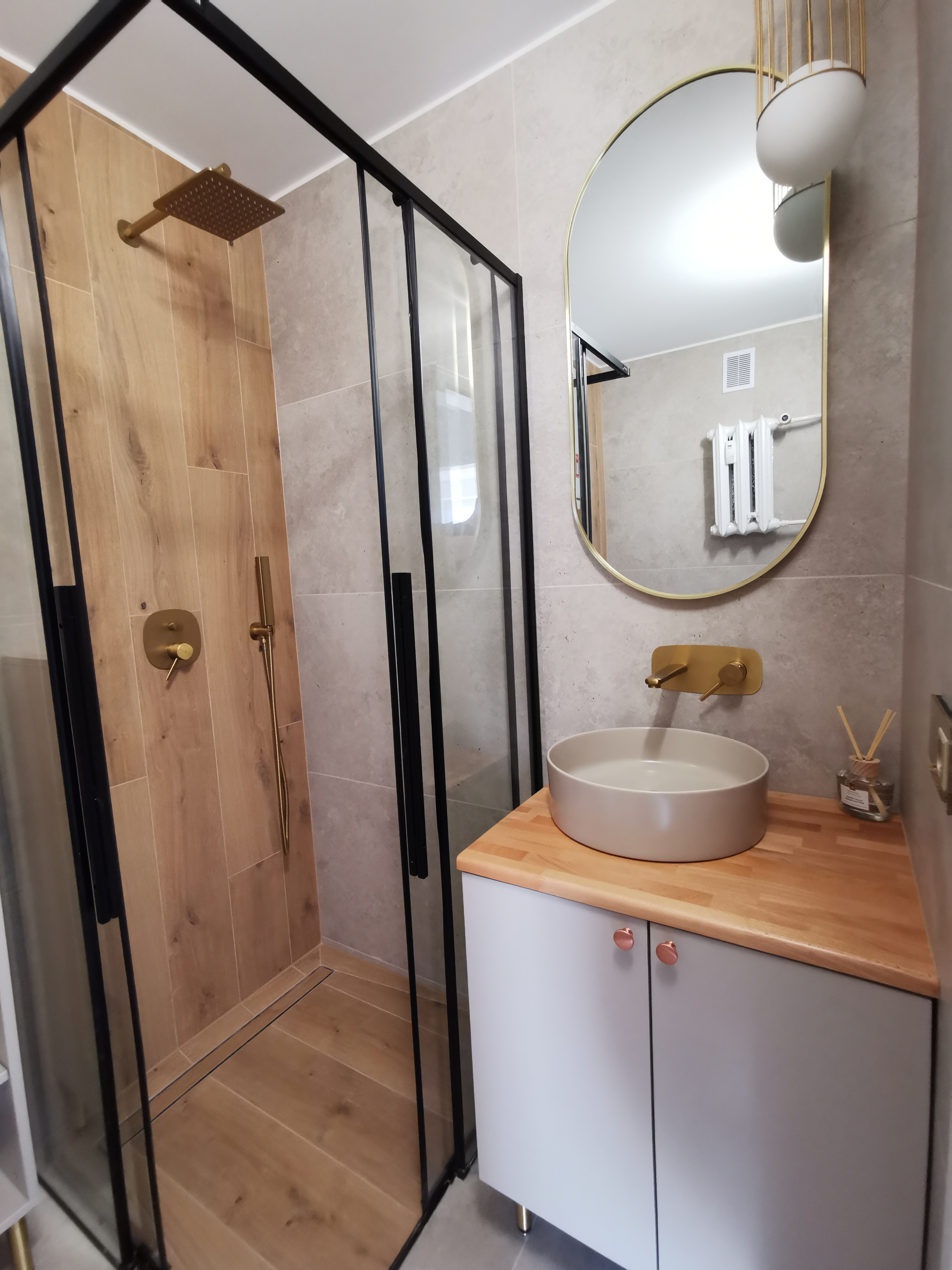 Łazienka ze złotymi armaturami i drewnianymi akcentami