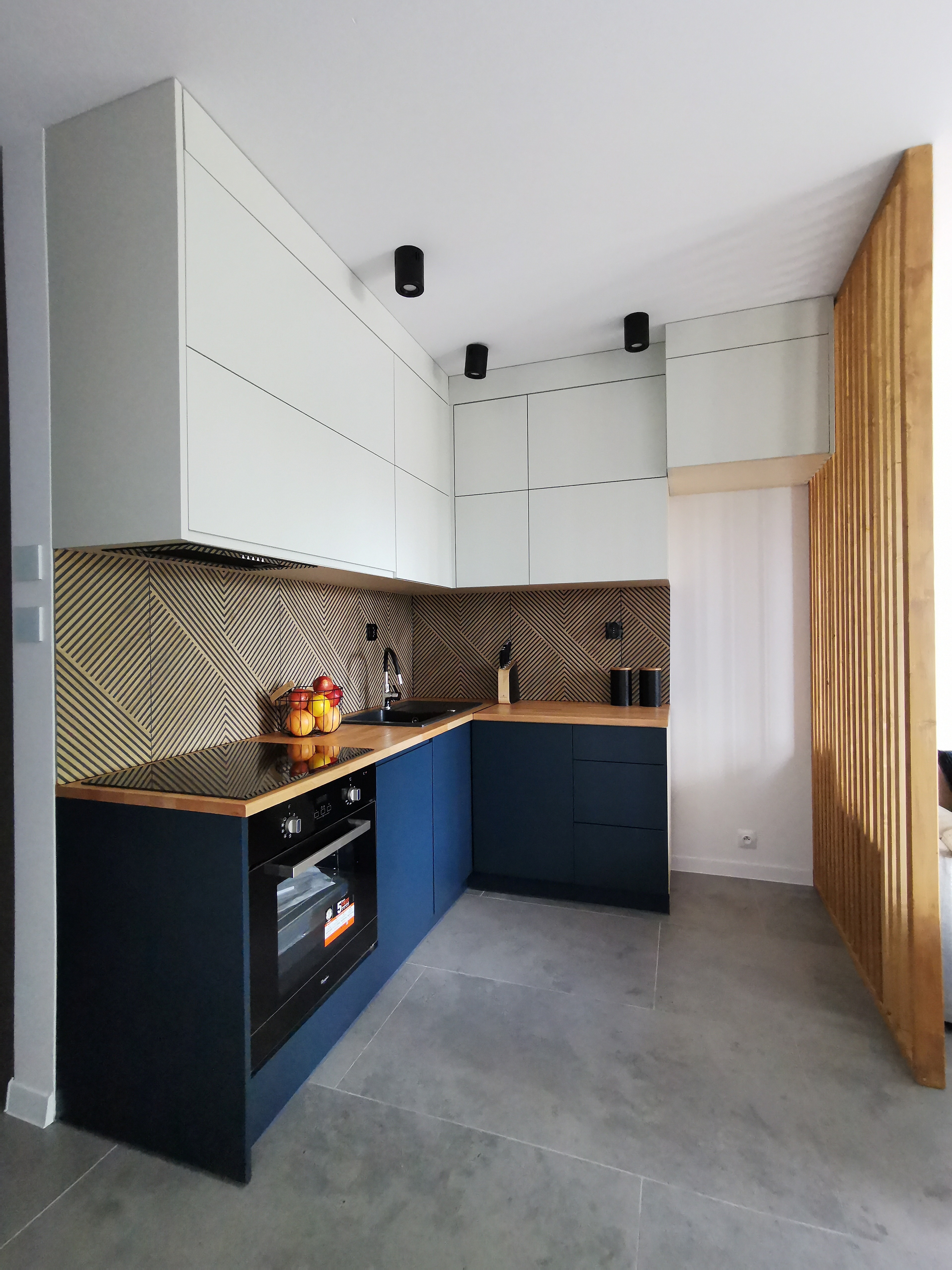 Kuchnia pod klucz z niebieskimi szafkami dolnymi i drewnianym blatem